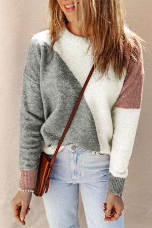 Geometric colorblock knit sweater in white, grey, and multicolor with crew neck.