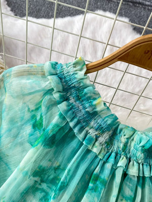 Light green and blue tie-dye bikini with smocked ruffle detail and bow.