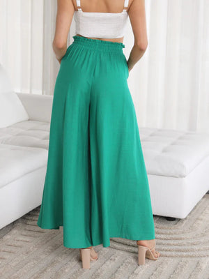 Textured drawstring palazzo trousers in green with wide legs and pockets.