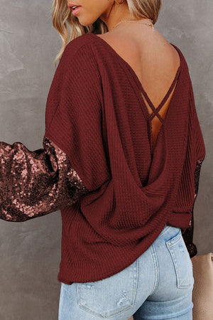 Burgundy waffle knit top with sequin sleeves and crisscross back detail
