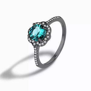 Elegant sterling silver ring with a teal zircon and diamond halo.