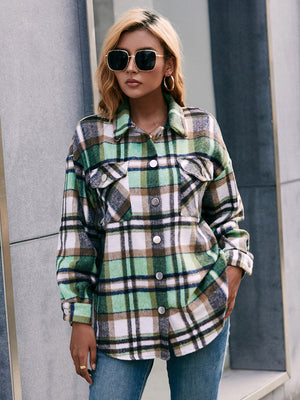 Oversized green plaid flannel shacket with buttoned patch pockets and a collared neckline.