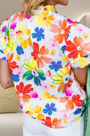 Vibrant floral print blouse with ruffle collar and short sleeves.