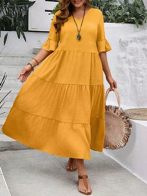 Yellow tiered midi dress with ruffle sleeves and crinkled fabric.