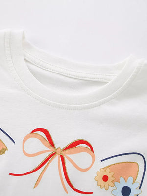 White cotton baby tee with embroidered cat ears, bow, and floral details.