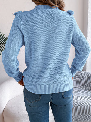 Light blue textured knit sweater with ruffle yoke detail and mock neck.