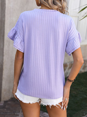 Lavender textured blouse with flutter sleeves and a striped pattern, styled with white shorts.