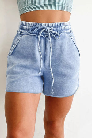 Light blue acid-washed cotton drawstring shorts with pockets and frayed hem