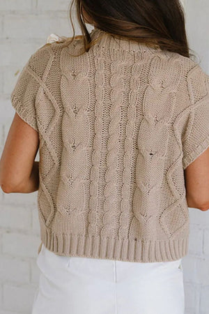 Mocha cable knit mock neck sweater with short sleeves and bow detail on shoulder.