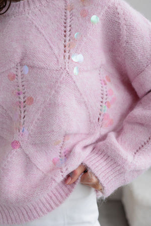 Blush pink diamond knit sweater with sequin embellishments and open knit details.