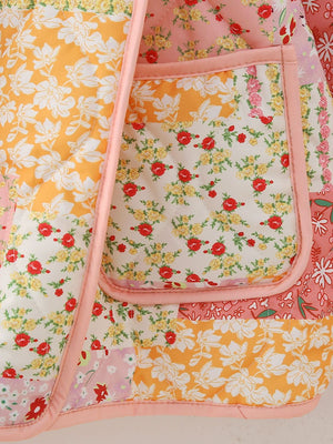 Floral quilted patchwork jacket with pink trim and pocket detail.