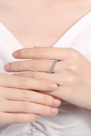 Pavé band sterling silver ring with small stones, worn on a finger.
