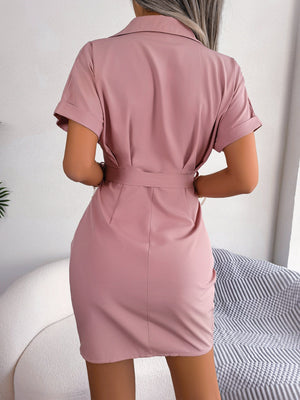 Belted shirt dress in blush pink with short sleeves and a collared neckline.