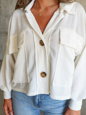 Textured white boxy utility shirt jacket with button front and chest pockets.