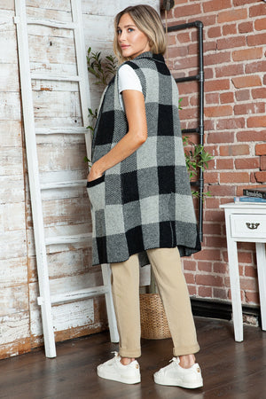Geometric knit duster vest in black and tan buffalo check pattern with pockets.