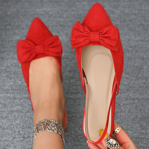 Red bow slingback flats with pointed toe and ankle strap detail.