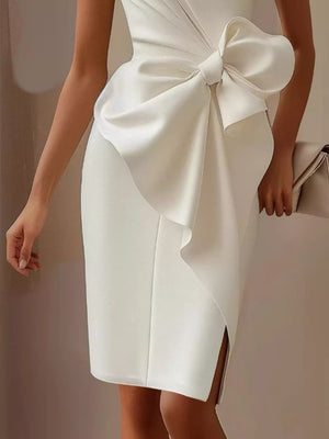 White sleeveless dress with a large bow detail and side slit.