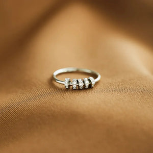 Sterling silver ring with five rows of pavé-set stones on a brown satin background.