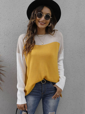 Colorblock crewneck knit sweater in gold, cream, and white with side slits.