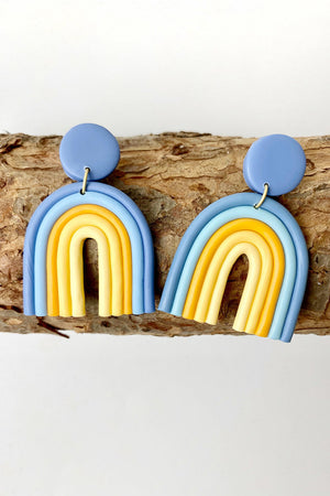 Clay rainbow arch earrings in dusty blue and yellow with a round stud.