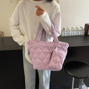 Quilted lilac tote bag with matching pouch and diamond pattern.