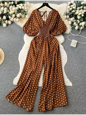 Caramel polka dot smocked wide-leg romper with V-neck and tie back.