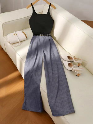 Chic sleeveless top with pinstripe wide-leg pants set in dark gray, styled with a belt and white handbag.