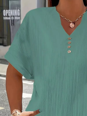 Textured green plus size V-neck t-shirt with decorative buttons and cuffed sleeves.