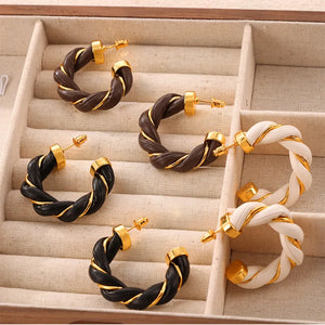 Braided leather and gold hoop earrings in black, coffee brown, and white.