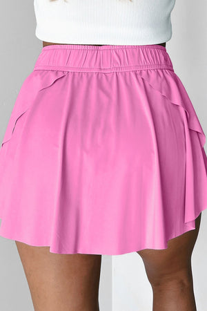 Fuchsia pink ruffled skort with elastic waistband and tie detail.