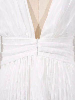 White maxi dress with ruched waist, V-neckline, and textured fabric.