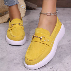 Yellow suede loafers with gold horse-bit detail and white soles.