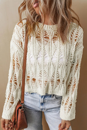 Ivory open-knit crochet crop sweater with a distressed, boho pattern and long sleeves.
