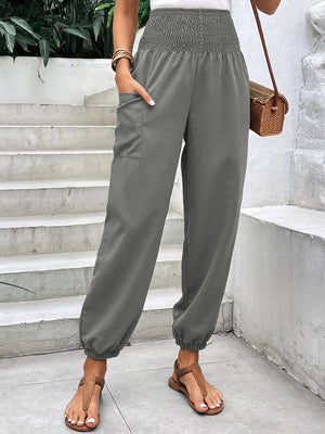 Gray relaxed-fit cargo pants with smocked waist and cinched ankles.