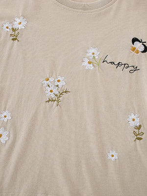 Beige cotton tee with embroidered daisies, butterflies, and "happy" text.