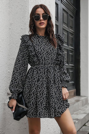 Black dot print dress with ruffle trim, long sleeves, and cinched waist.