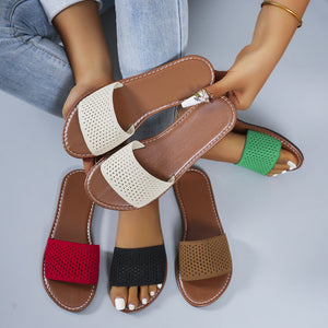 Perforated comfort slide sandals in beige, black, red, green, and cream with brown soles.