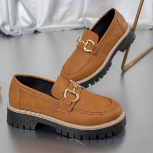 Terracotta chunky chain-detail platform loafers with gold hardware.