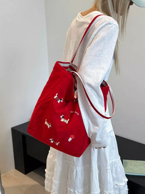Red shoulder bag with dachshund embroidery and striped straps