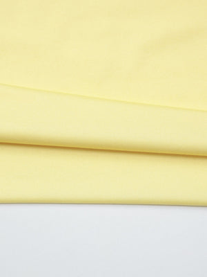 Off-shoulder ruched mini dress in pale yellow fabric with subtle texture.