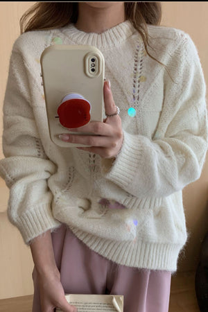 Ivory diamond knit sweater with sequin embellishments and open knit details.