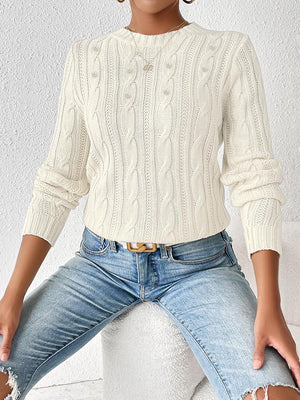 Ivory cable knit sweater with pearl embellishments and crew neck.