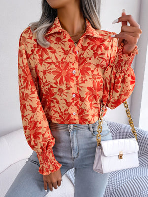 Floral print blouse in pumpkin with shirred cuffs and button front.