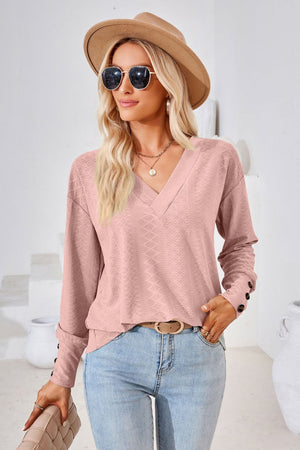 Blush pink textured v-neck blouse with button cuff long sleeves.