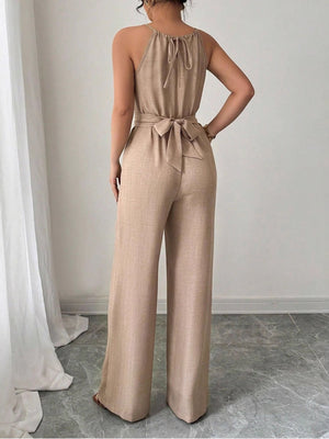 Beige halter neck wide leg jumpsuit with drawstring waist tie and back tie detail.