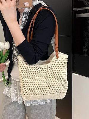 Beige woven straw shoulder bag with crochet detail and tan leather straps.