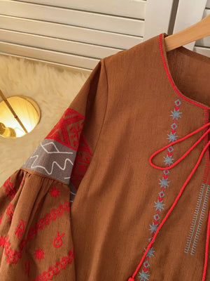 Brown folk-inspired tie neck shirt with red and grey embroidery on sleeves and neckline.