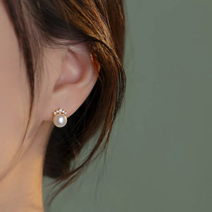 Lustrous pearl and zircon stud earrings with a delicate crown design.