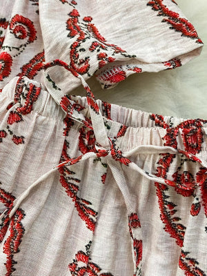 Two-piece set with red tropical print, drawstring waist, and belted detail.