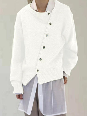 White asymmetric button-up knit cardigan with dark buttons and ribbed cuffs.